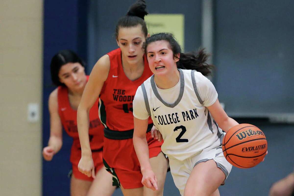 College Park's Gracie Garcia (2) drives down court in front of The Woodlands' Aurora Hernandez, center, and Tehya Rubio, left, during their District 13-6A girls basketball game at College Park High School Monday, Dec. 19, 2022 in The Woodlands, TX.