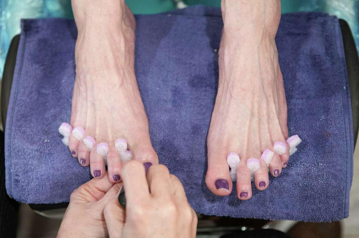 Leslie McKelfresh gets her toes painted by pedicure technician Lee Huynh at Heavenly Lashes Nail Spa on Monday, Dec. 19, 2022 in Houston. McKelfresh hasn’t been able to get pedicures until recently because of her chronic restless leg syndrome.