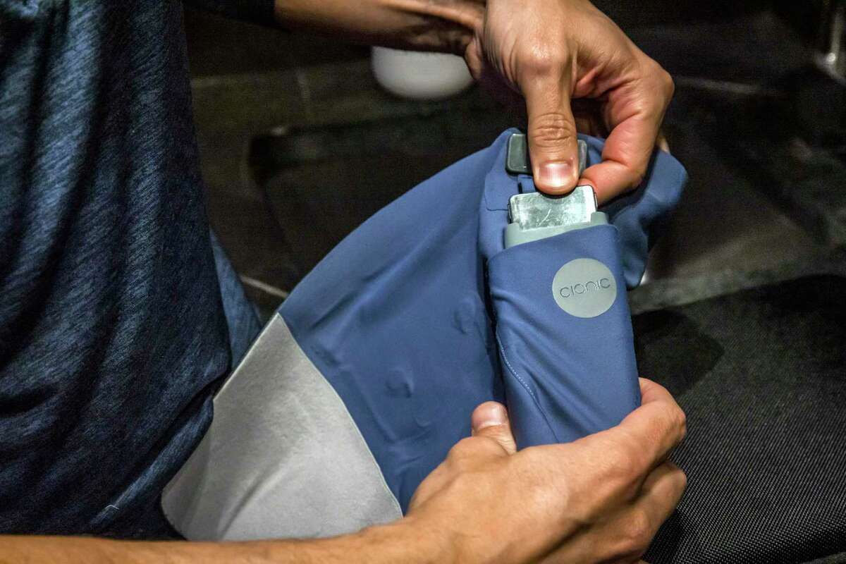 Jeremiah Robison holds the control unit in a neural sleeve he designed. The experimental technology can run for 8 to 12 hours on a battery.