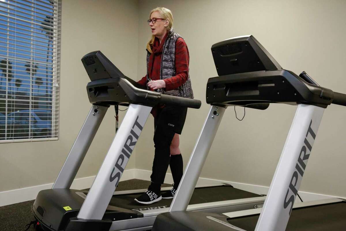 Patricia Allen walks on a treadmill with a Cionic harness.  After a stroke in 2019, Allen developed left-sided weakness.  She tested wearing Cionic sleeves with built-in electronics and sensors to help her walk.