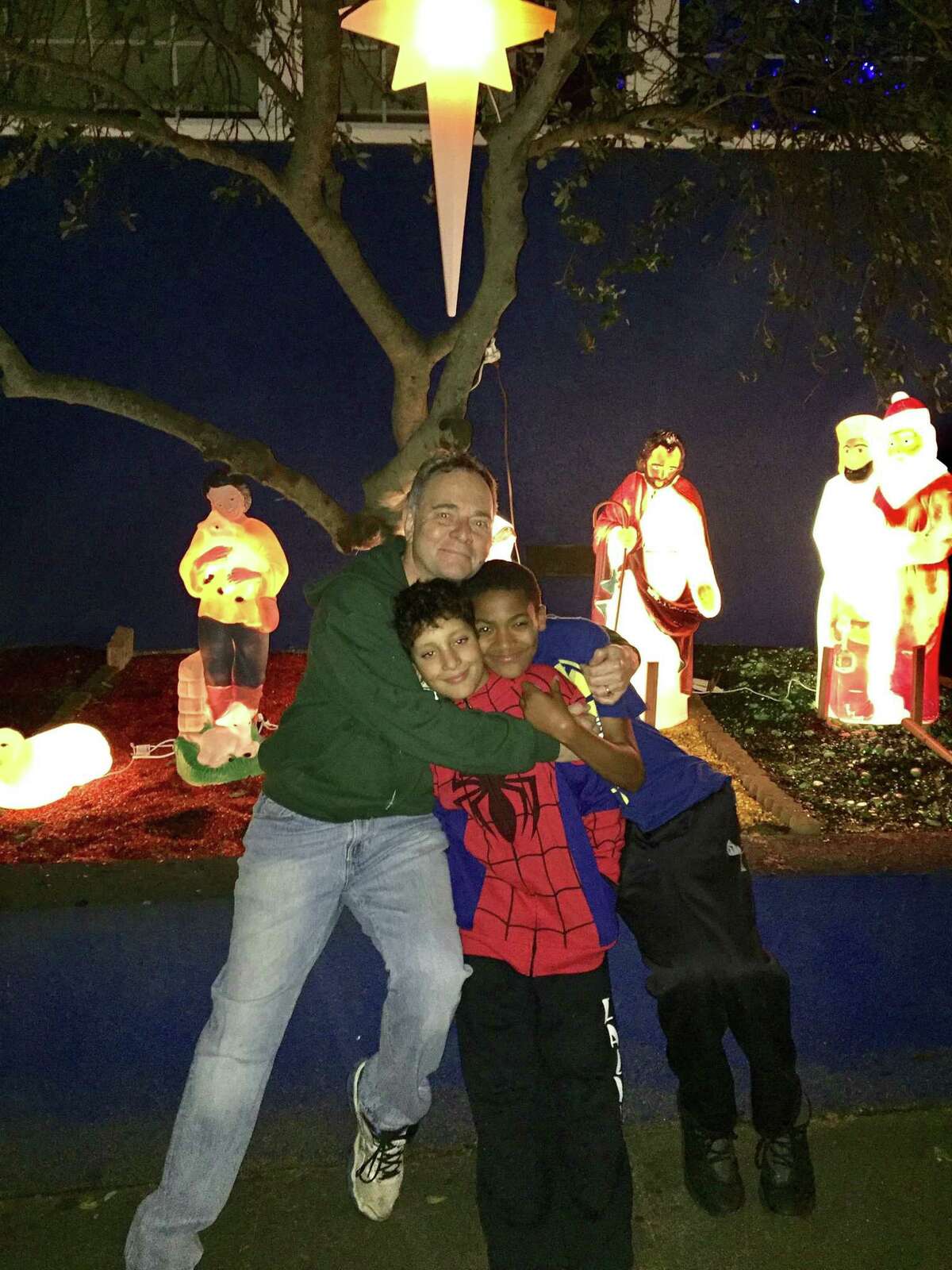 Kevin Fisher-Paulson with his sons in front of their light-up nativity scene.