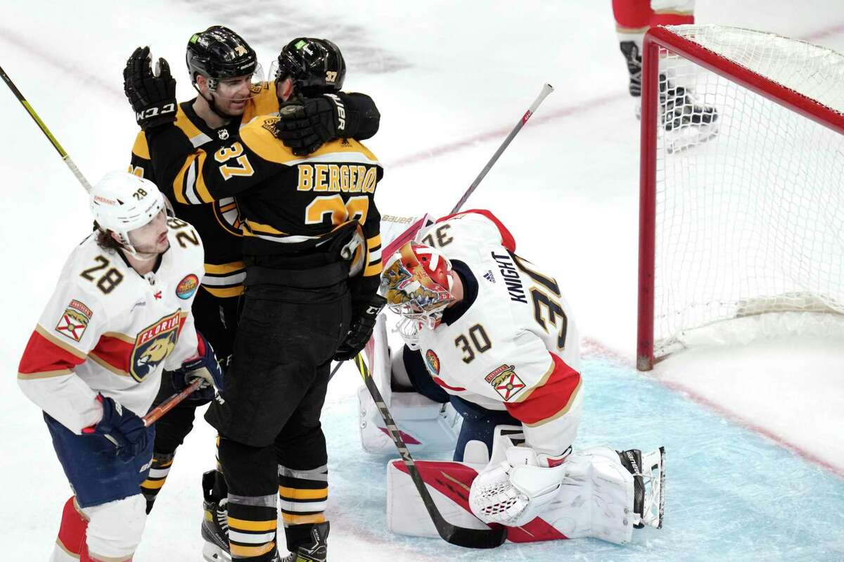 Boston Bruins center Patrice Bergeron (37) is congratulated by teammate Jake DeBrusk after his goal against Florida Panthers goaltender Spencer Knight (30) during the third period of an NHL hockey game, Monday, Dec. 19, 2022, in Boston. (AP Photo/Charles Krupa)