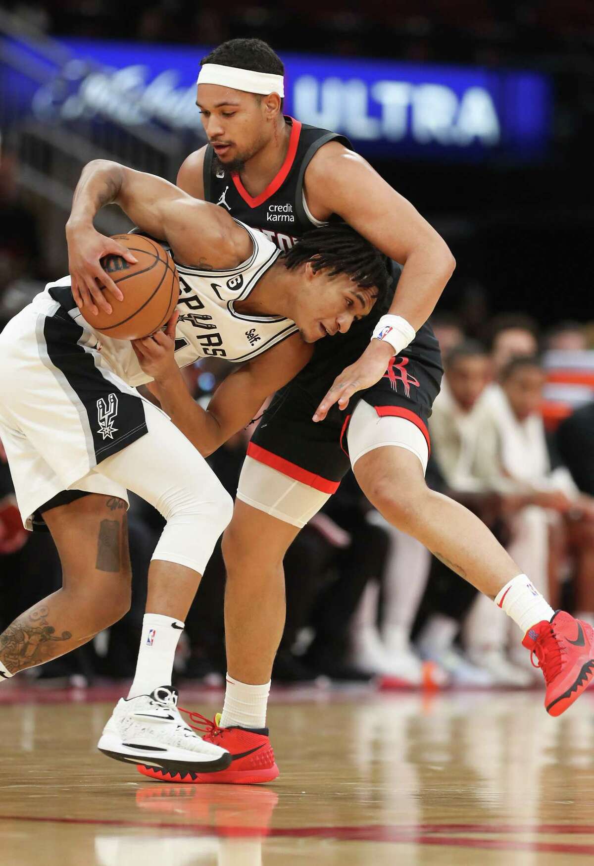 San Antonio Spurs guard Devin Vassell (24) drives into Houston Rockets guard Daishen Nix (15) in the first half at the Toyota Center on Monday, Dec. 19, 2022 in Houston.