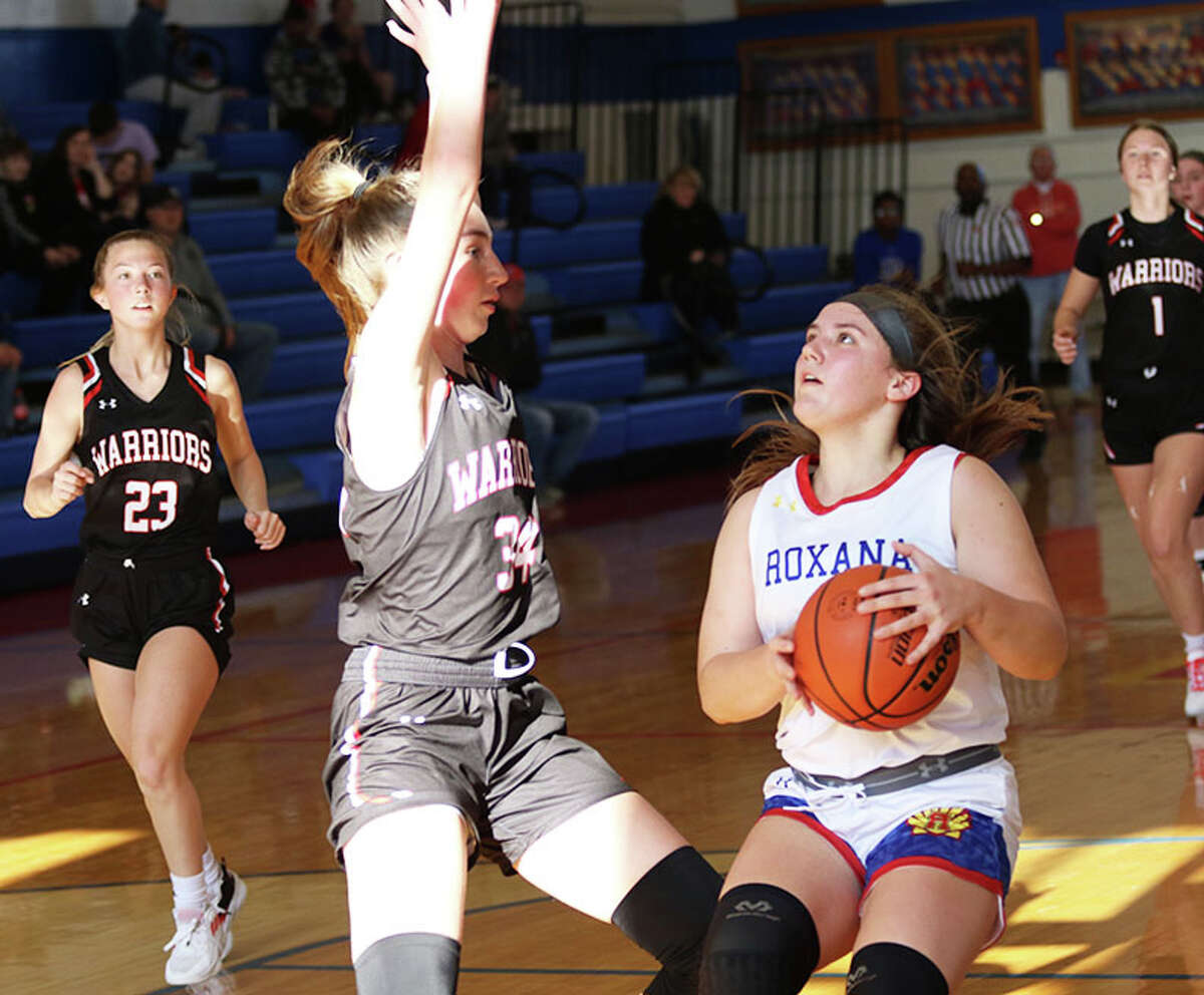 Roxana's Kinsley Mouser (right) puts the ball in the basket in a November game at Roxana against Calhoun's Kate Zipprich. The Shells lost Monday night in Columbia while Calhoun's home game against Staunton was postponed due to illness.