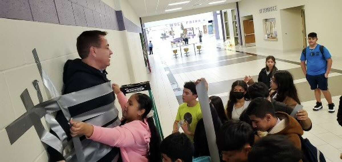 Freshmen students at LBJ High School participated in the Women's City Club's "Pennies for Tennies" fundraiser, and the winning class got to duct tape administrator Eduardo Davila to the wall as a reward. 