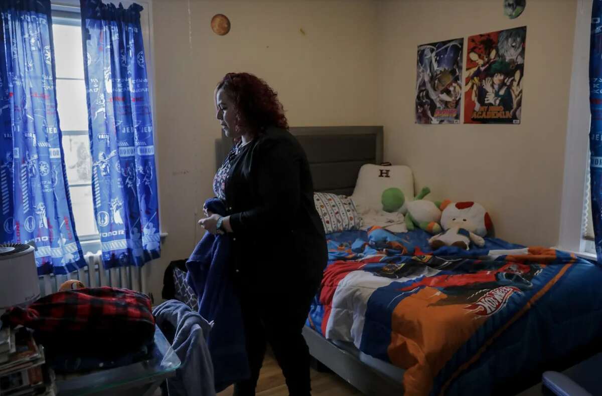 Carmen Diaz cleans her 9-year-old son’s room in Hamden. 