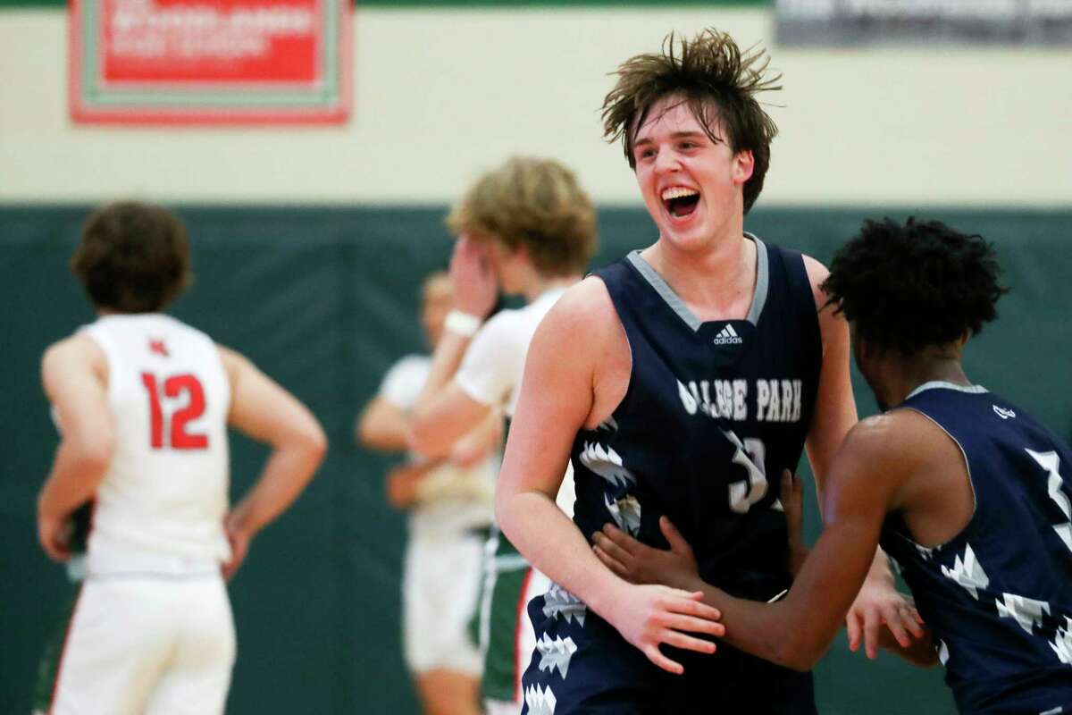 College Park small forward Zane Cooper (32) celebrates with guard Khayden Pitre (3) after defeating The Woodlands 69-64 in overtime of a District 13-6A high school basketball game at The Woodlands High School, Tuesday, Dec. 20, 2022, in The Woodlands.