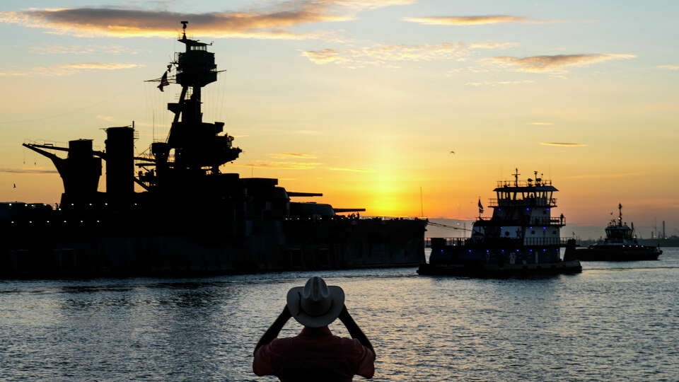 The sun rises behind the Battleship Texas as the ship is towed into the Houston Ship Channel Wednesday, Aug. 31, 2022 in La Porte. The ship is making the journey to a dry dock in Galveston for a complete overhaul of the 108-year-old dreadnought, that served in both world wars.