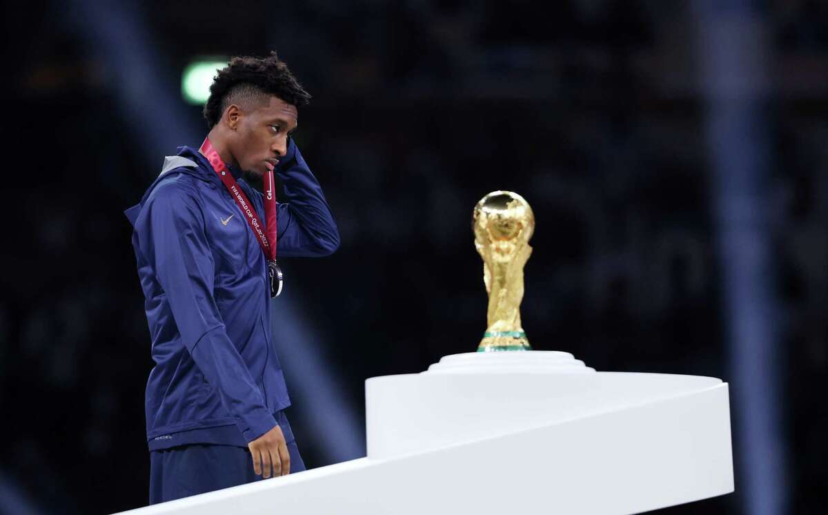 LUSAIL CITY, QATAR - DECEMBER 18: Kingsley Coman of France walks past the FIFA World Cup Qatar 2022 Winner's Trophy during the awards ceremony after the FIFA World Cup Qatar 2022 Final match between Argentina and France at Lusail Stadium on December 18, 2022 in Lusail City, Qatar.