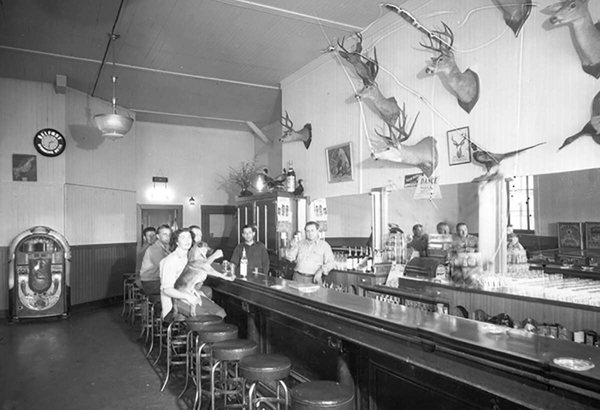 Patrons, a puppy and the ominous jukebox inside the saloon in 1949.
