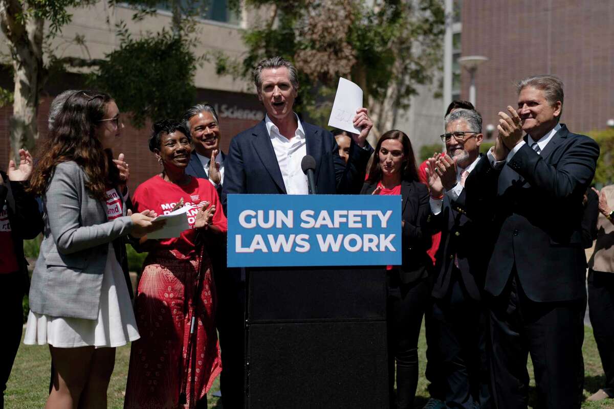 California Gov. Gavin Newsom celebrates after singing a gun control law at Santa Monica College on July 22, 2022.