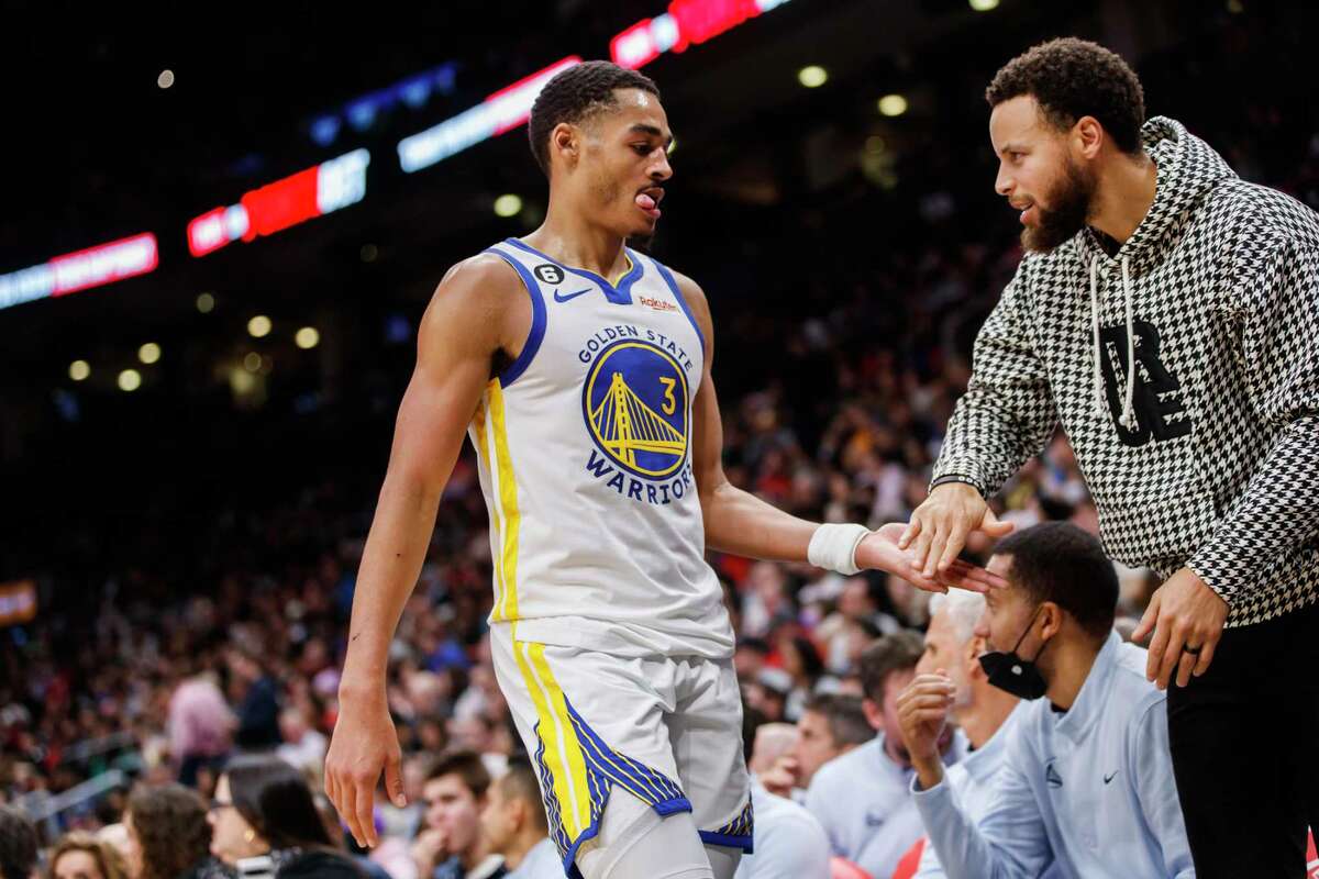 TORONTO, ON - DECEMBER 18: Jordan Poole #3 is welcomed to the bench by Stephen Curry #30 of the Golden State Warriors in the final minutes of their NBA game against the Toronto Raptors at Scotiabank Arena on December 18, 2022 in Toronto, Canada. NOTE TO USER: User expressly acknowledges and agrees that, by downloading and or using this photograph, User is consenting to the terms and conditions of the Getty Images License Agreement. (Photo by Cole Burston/Getty Images)