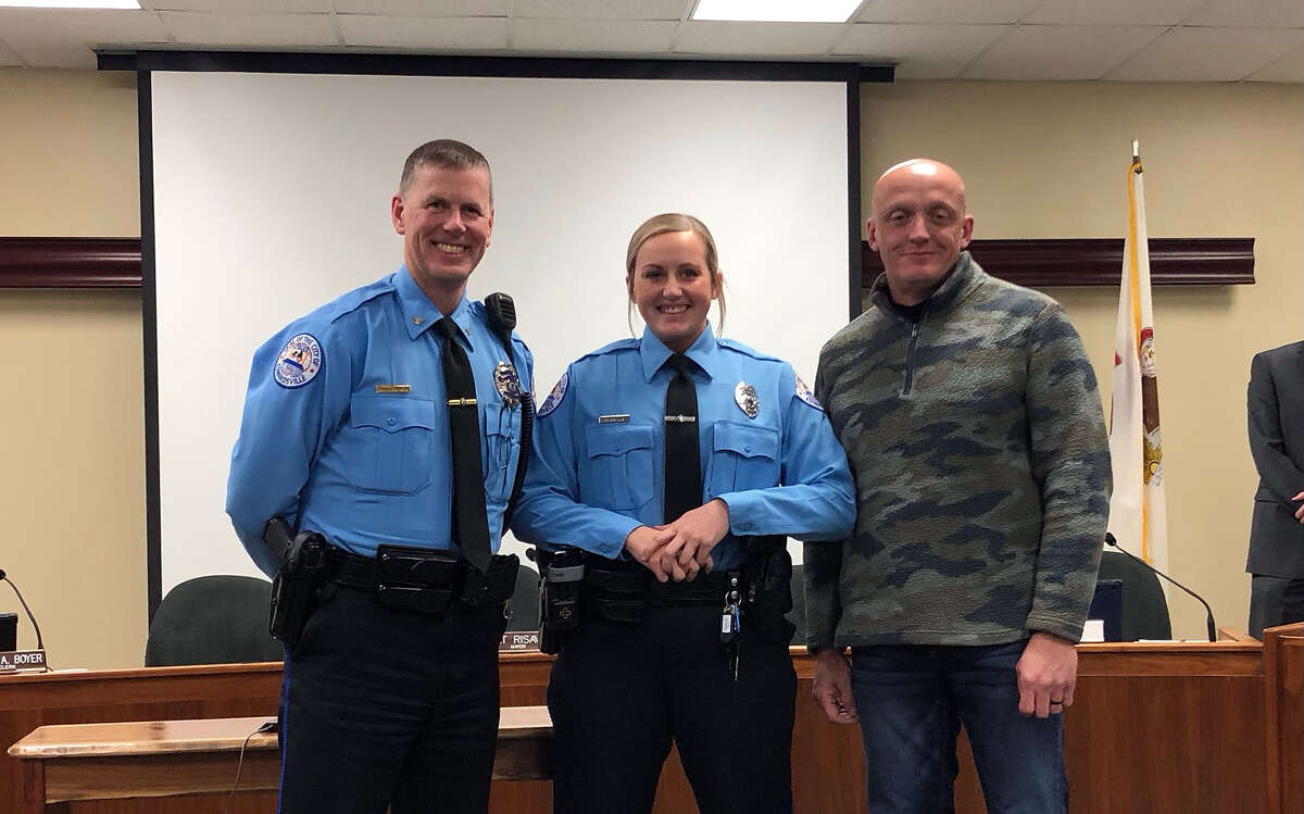 Edwardsville Police Chief Michael Fillback, left, with Madison Rapien, center, and family Tuesday at city council. Rapien was one of three new police officers sworn in.