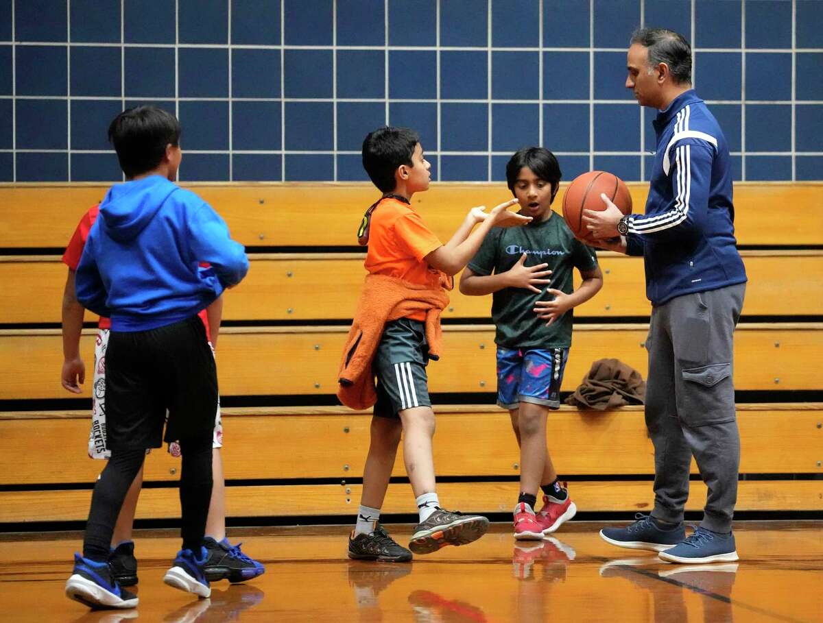 Coach Fiaz Zaman hands the ball to Rayyan Hashmi as the Bellaire youth winter basketball team held their practice at the Bellaire Parks and Recreation recreation center on Tuesday, Dec. 20, 2022 in Bellaire.