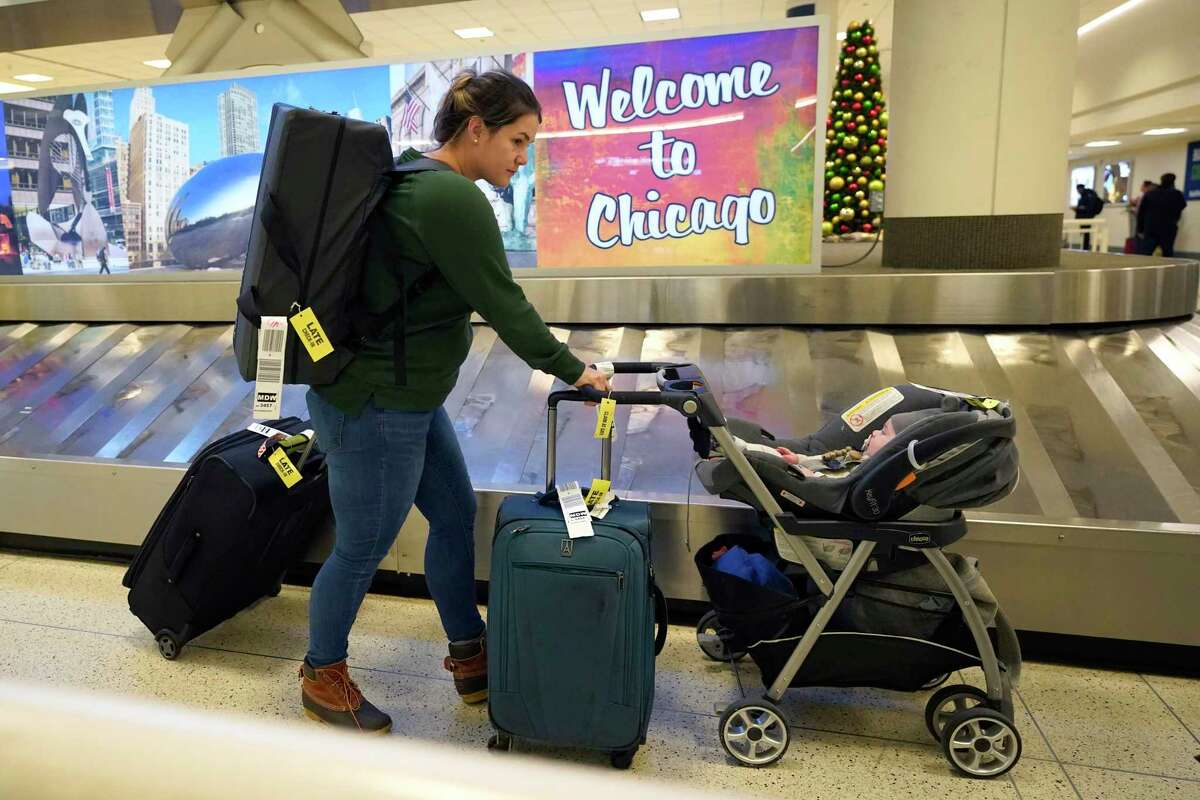 Wimberly Hoogendoorn from Houston, Texas, gathers her luggage at Chicago's Midway Airport for a family holiday visit just days before a major winter storm Tuesday, Dec. 20, 2022, in Chicago.