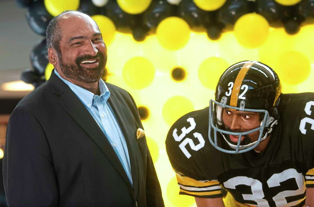 FILE - Former Pittsburgh Steelers running back Franco Harris stands next a statute of himself on Sept. 12, 2019, at Pittsburgh International Airport near Pittsburgh. Harris died on Wednesday morning, Dec. 21, 2022, at age 72, just two days before the 50th anniversary of The Immaculate Reception. (Nate Guidry/Pittsburgh Post-Gazette via AP, File)