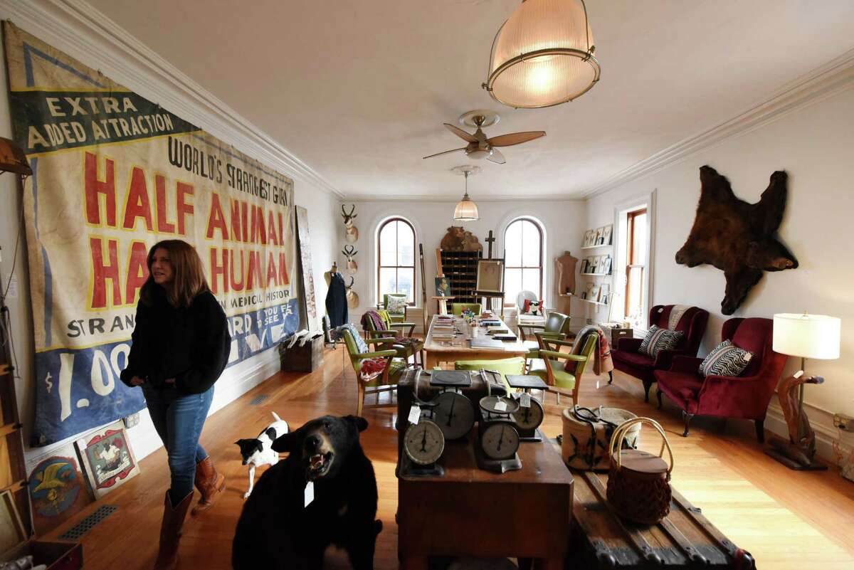 Former magazine editor Sarah Gray Miller walks the upper floor showroom of her antiques store, UnQuiet Antiques, on Thursday, Dec. 8, 2022, in Coxsackie, N.Y.