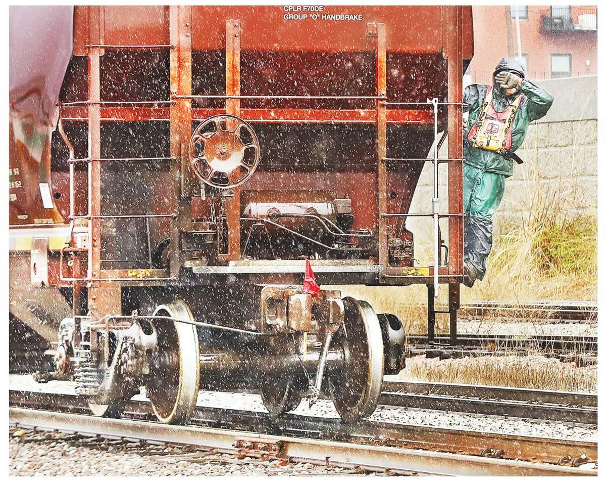 A railroad employee covers his face during working in a March 2022 storm. Industry representatives attending the Country Elevator Conference and Trade Show earlier this month in St. Louis say their current focus is to build crew numbers and improve overall rail service.