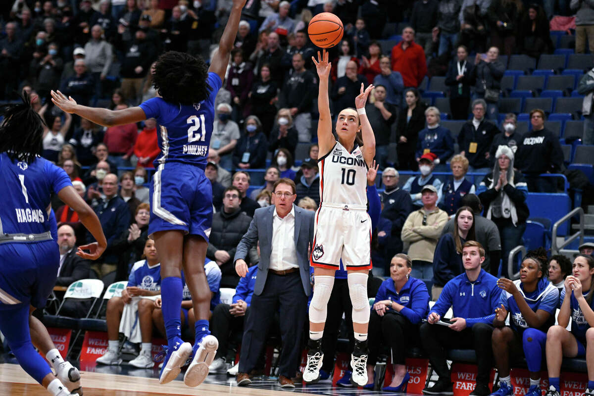 Connecticut's Nika Muhl (10), from Croatia, makes a 3-point basket over Seton Hall's Shailyn Pinkney (21) in the first half of an NCAA college basketball game, Wednesday, Dec. 21, 2022, in Hartford, Conn. (AP Photo/Jessica Hill)