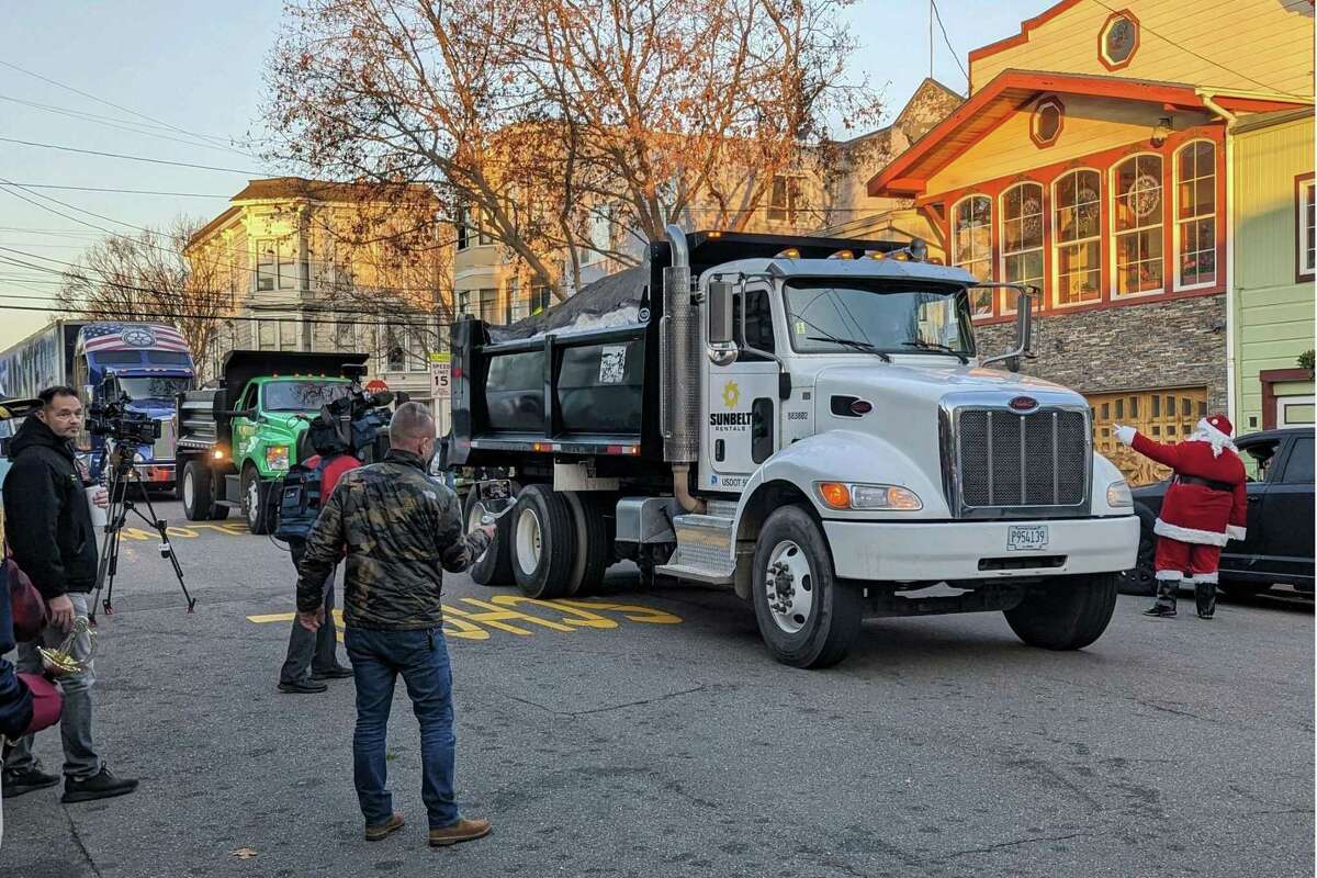 Teamsters Union drivers deliver Tahoe snow in dump trucks to a fire station on 25th Street in San Francisco for a community holiday party on Wednesday, Dec. 21, 2022.
