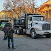 2022年12月21日星期三，卡车司机联盟的司机用自卸卡车将太浩湖积雪运送到旧金山25街的消防站，参加社区节日派对。
