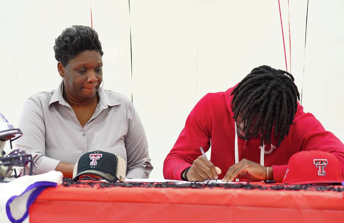 Tonya Russel watches as her son, Humble senior varsity football receiver Tyrone West, signs a commitment to Texas Tech at Humble High School on Wednesday, Dec. 21, 2022 in Houston.