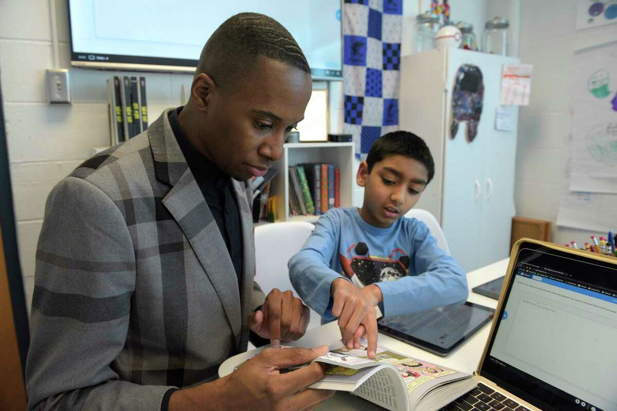 Randall Austin, assistant principal of Kendall School, works with Ansh Shah during what is know as “What I Need”. They were working on reading comprehension. Wednesday, December 21, 2022. Norwalk, Conn.