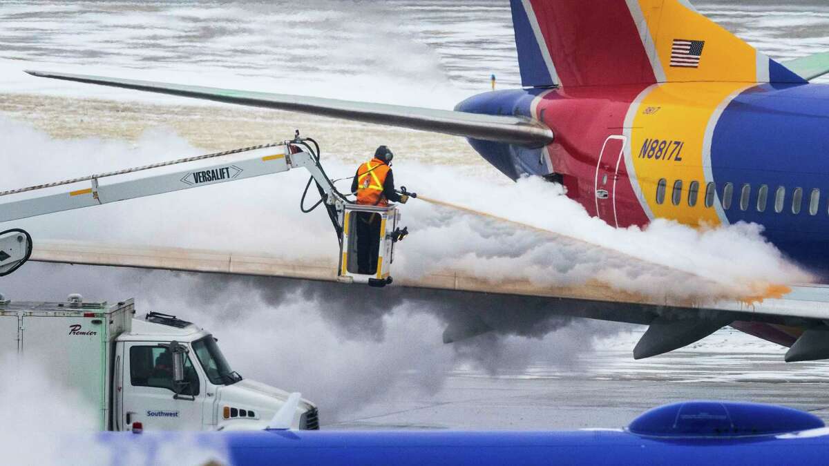 Crews deice a Southwest Airlines plane before takeoff on Wednesday, Dec. 21, 2022 in Omaha, Neb. An incoming winter storm threatens the Christmas travel rush. (Chris Machian/Omaha World-Herald via AP)