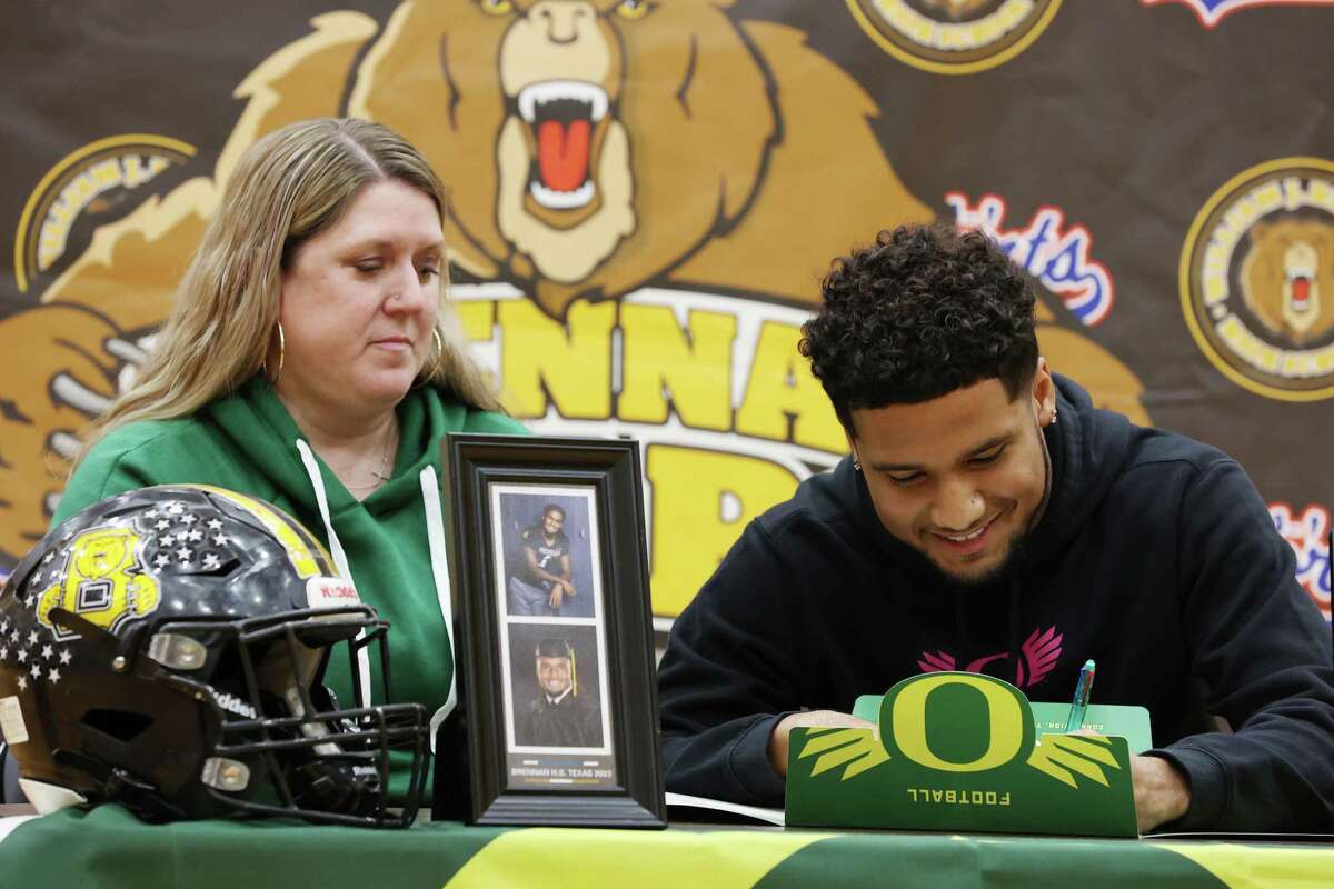 Brenan High School’s Tyler Turner signs with Oregon during a ceremony at the school, Friday, Dec. 16, 2022. Turner will head to Oregon and practice with the team before their appearance in the Holiday Bowl against North Carolina Tar Heels on Dec. 28 in San Diego, California. His mother, Jessica Tuner, is on the left.