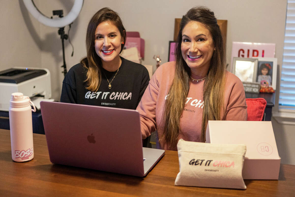 Sisters Toni Lee, left, and Mei-Lon Jimenez pose Tuesday, Dec. 21, 2022, in the home office they use to run their Chica Beauty cosmetics line. The company recently received a $25,000 grant from Bank of America and MasterCard during an appearance on the Jennifer Hudson Show.