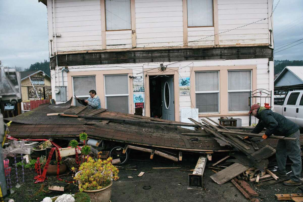Darren Gallagher (back left) and a neighbor remove a damaged balcony in Rio Dell (Humboldt County).