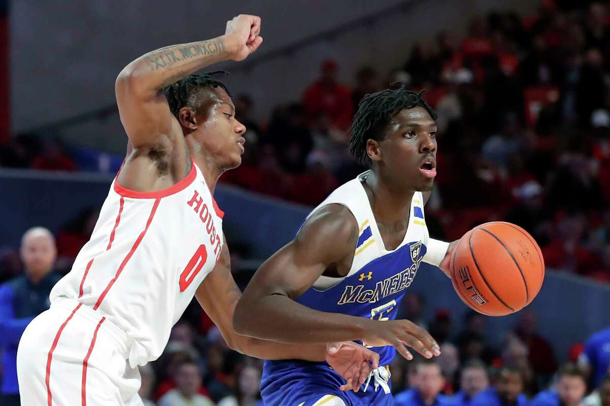 McNeese State guard Johnathan Massie, right, works around Houston guard Marcus Sasser (0) during the first half of an NCAA college basketball game Wednesday, Dec. 21, 2022, in Houston. (AP Photo/Michael Wyke)