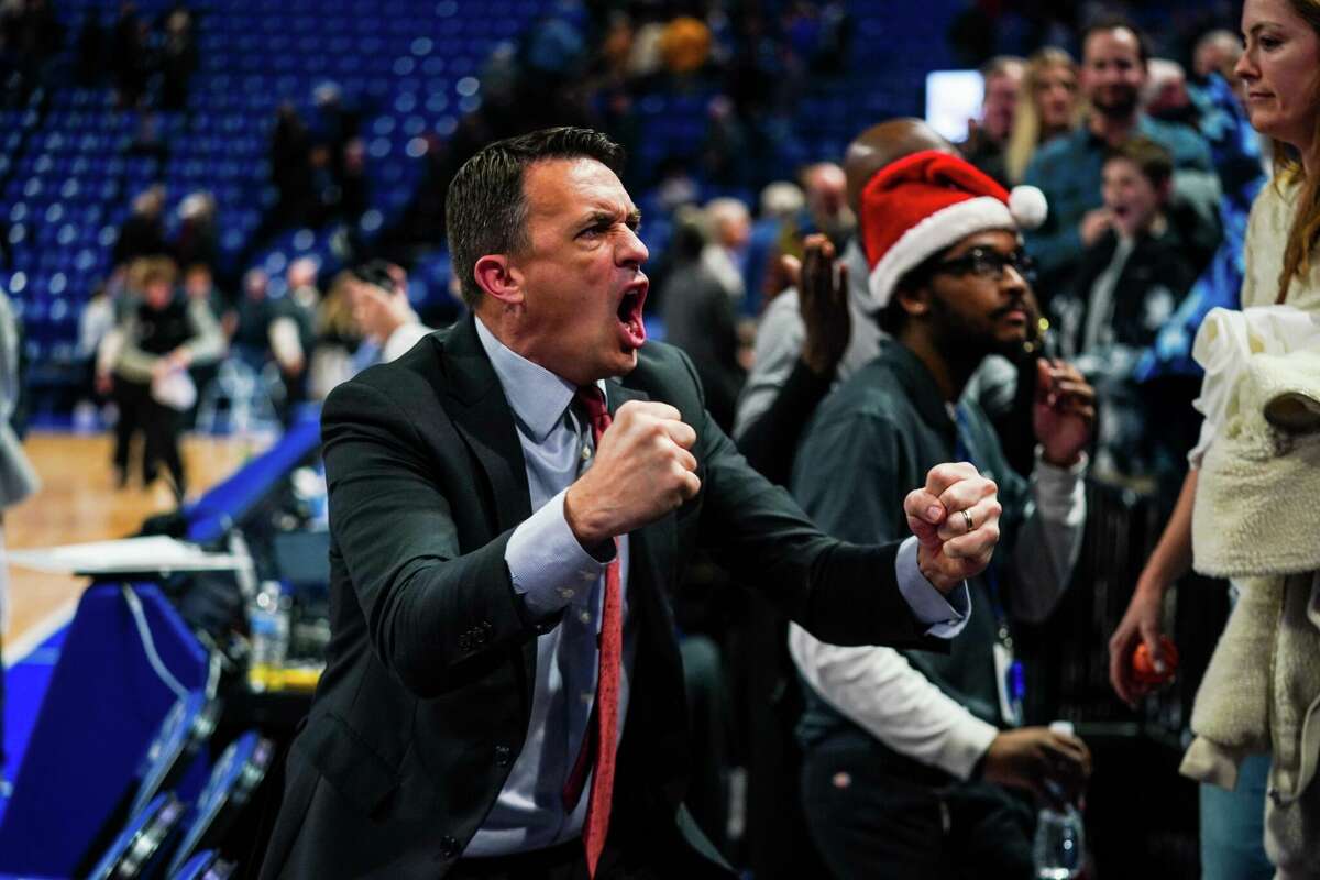 SIUE coach Brian Barone pumps his fists in celebration after his team's win over Saint Louis University inside Chafietz Arena in Saint Louis.