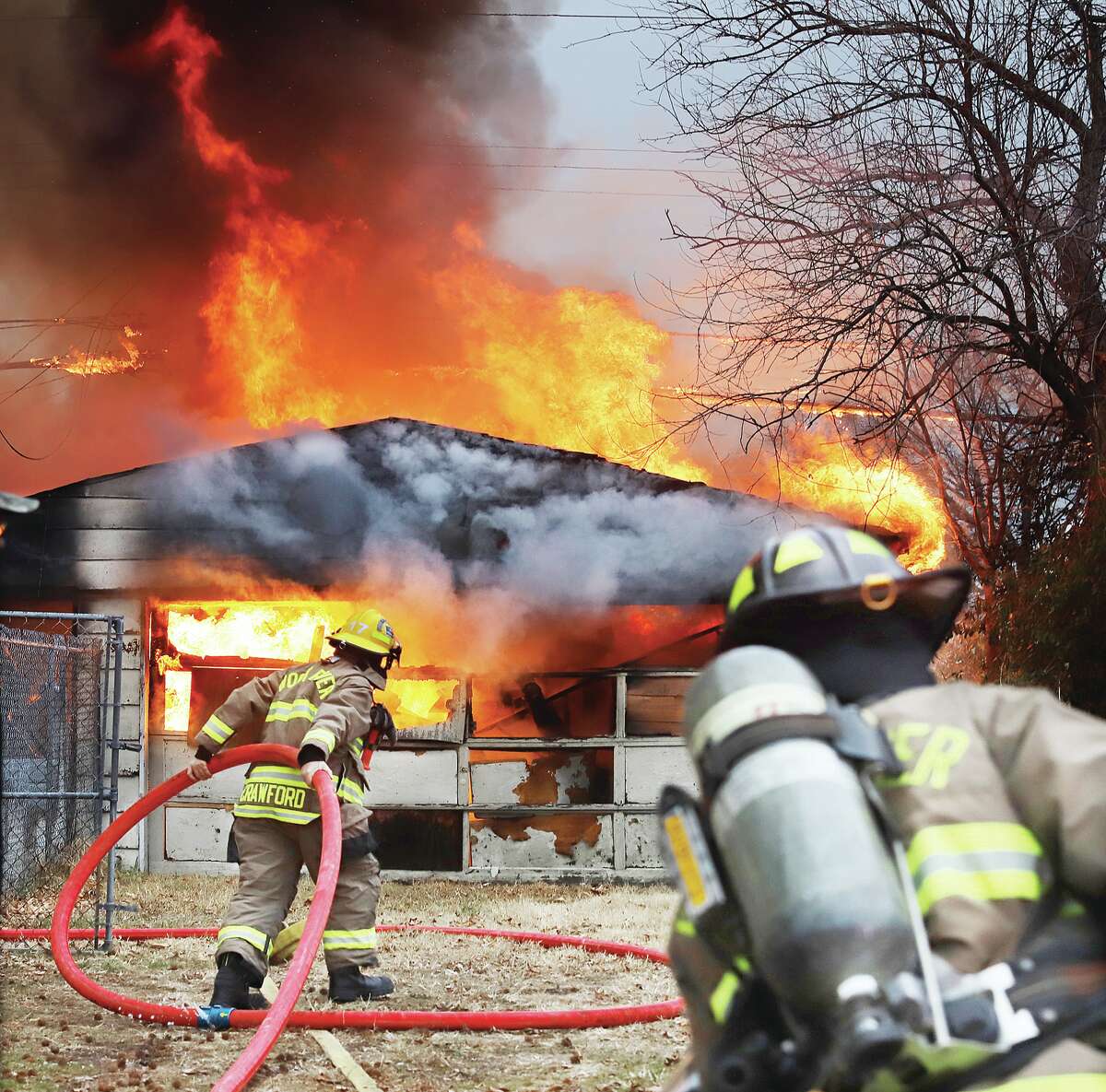 John Badman|The Telegraph Wood River firefighters advance hose to the large detached garage that caught fire Wednesday in the 100 block of East Penning Avenue in Wood River. 