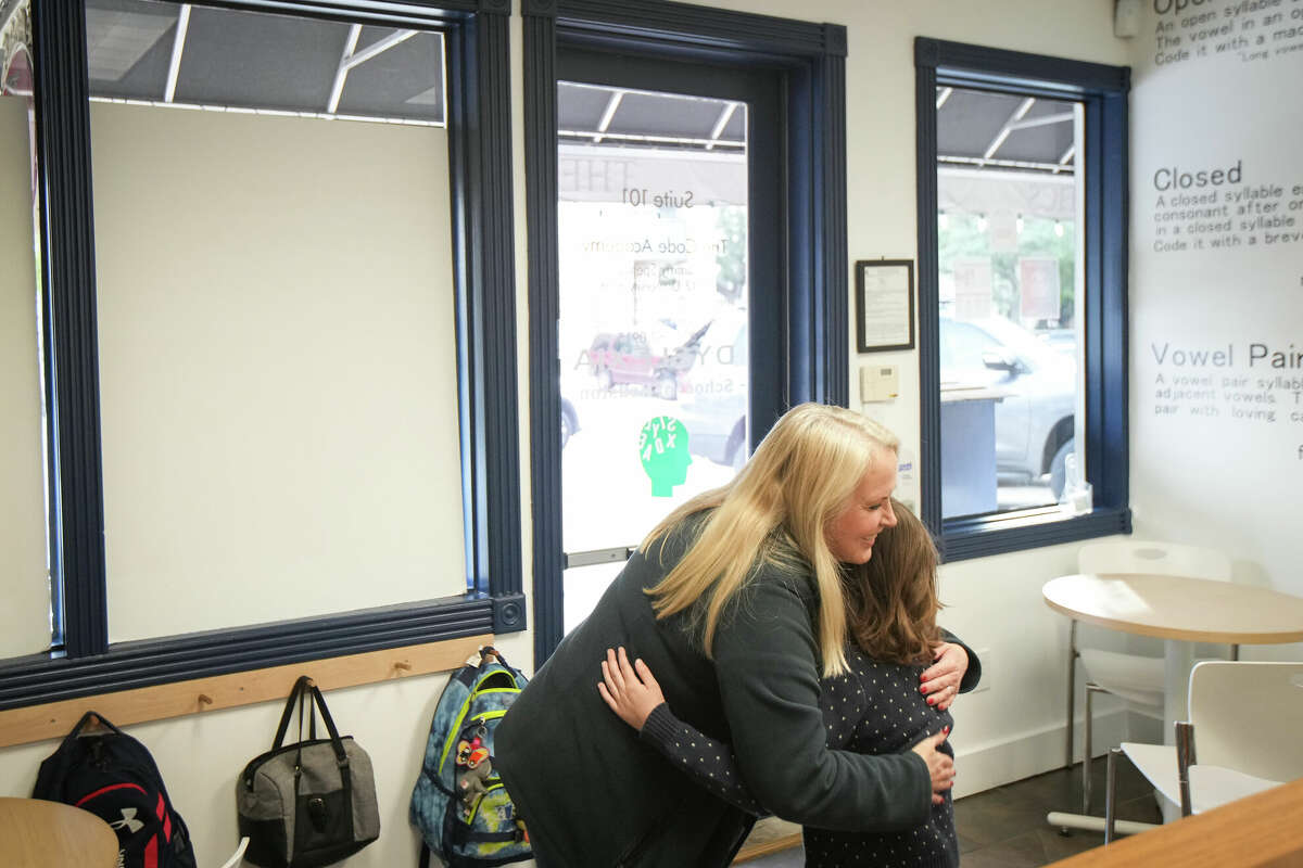 Tammy Spencer, founder of Dyslexia School of Houston, hugs a student as he arrives Wednesday, Dec. 21, 2022, at the school in West University Place.
