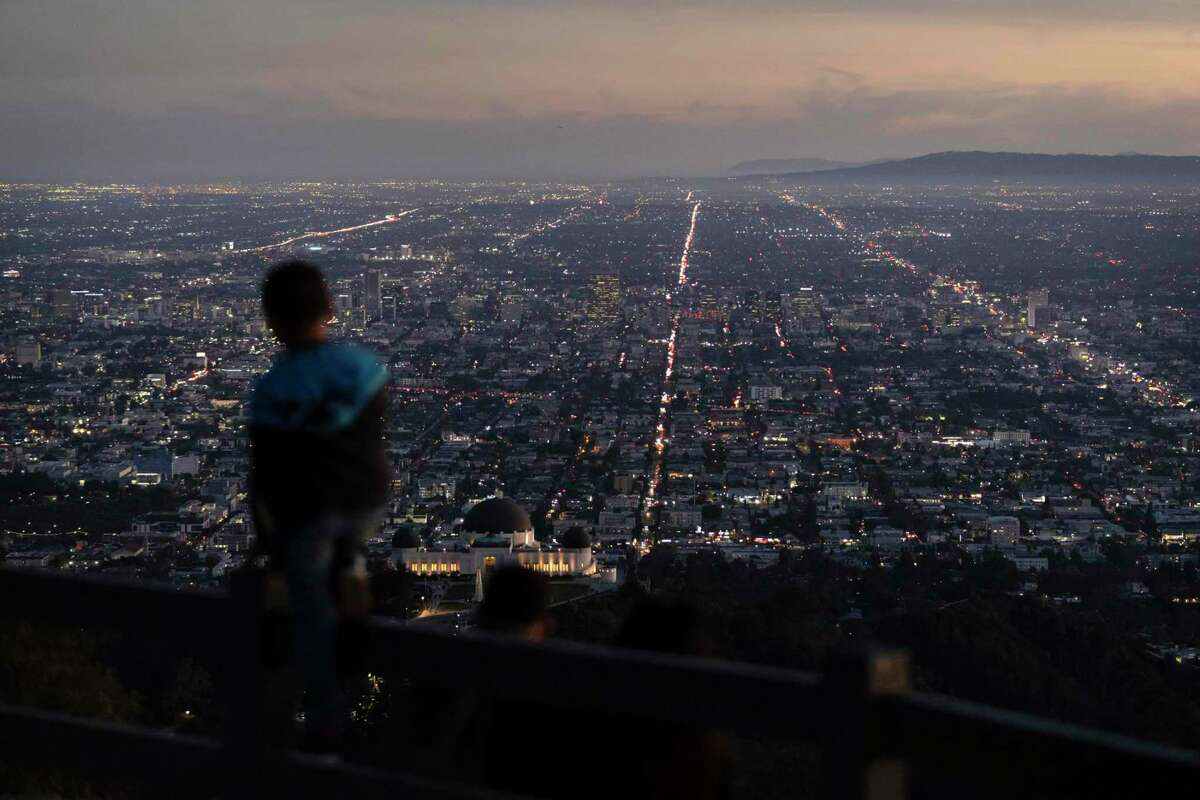 A boy takes in the view of the Los Angeles skyline from the Griffith Park Observatory. California’s population is on a downward trajectory.