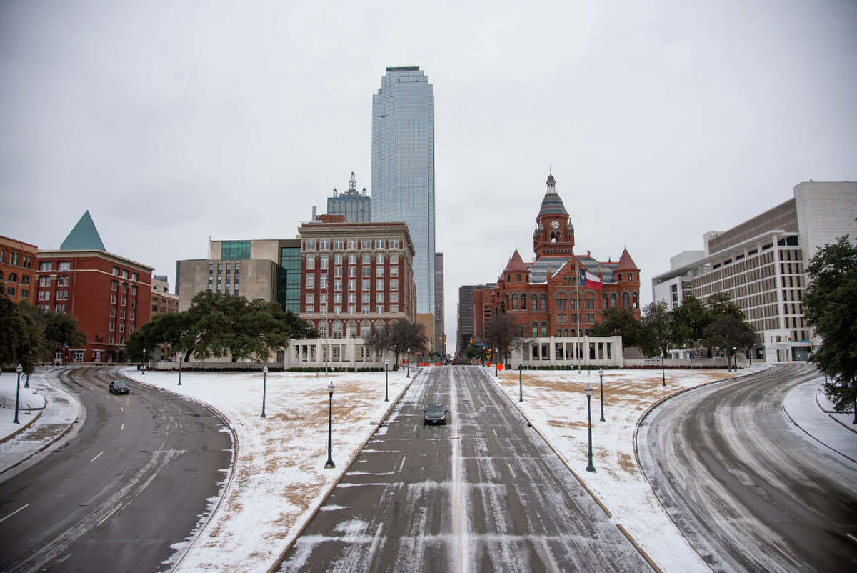 Cars drive through downtown Dallas covered in ice and snow in February 2021.