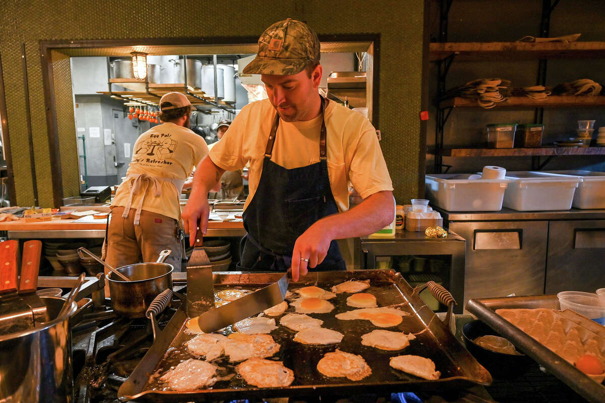 Egg Pals owners Brack DeFries and Chris Morgan cooking eggs on the grill at Ramen Shop on Sunday, Dec. 18, 2022.