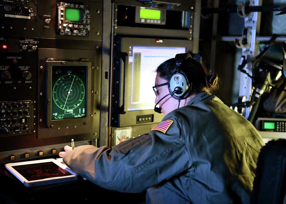 索尼娅·沃克少校，第53天气侦察中队的飞行气象学家，在一次飞行中，在一次下探仪部署后写下坐标。