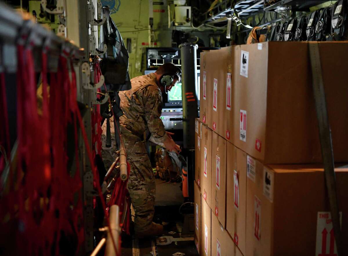 Master Sgt. Chris Becvar, a loadmaster for the 53rd Weather Reconnaissance Squadron, opens a dropsonde tube in preparation to load it during a flight.