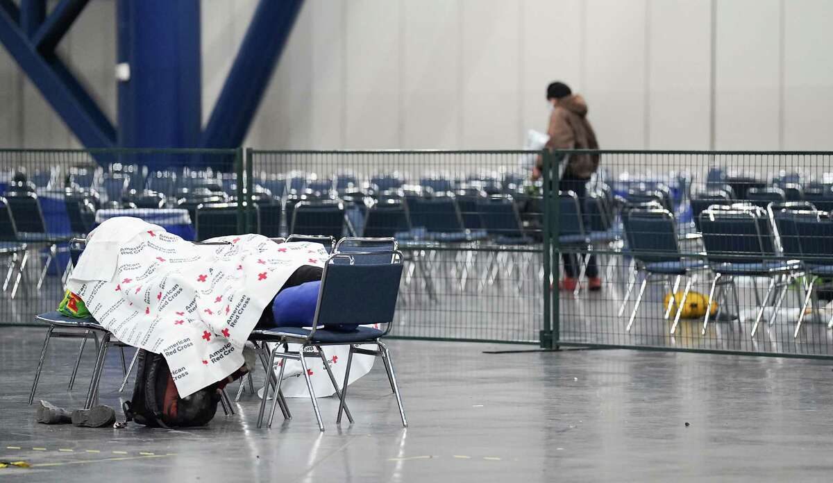 Using a Red Cross blanket, a idiosyncratic   sleeps astatine  the exigency  warming halfway  opened astatine  George R. Brown Convention Center connected  Thursday, Dec. 22, 2022 successful  Houston. The metropolis  plans to support  the warming center, which has chairs, nary  cots, unfastened  until Saturday.