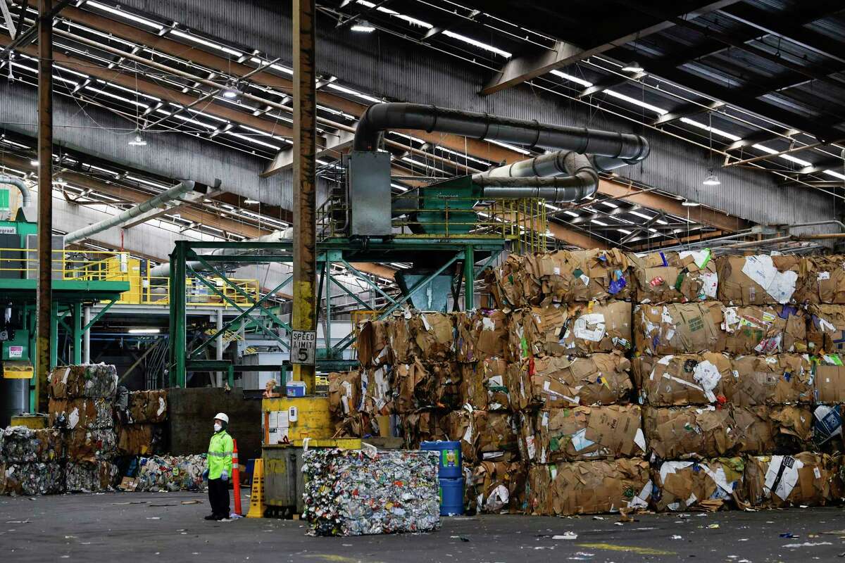 Bales of recycled materials including cardboard, soft plastics and aluminum pile high at Recology Recycle Central in San Francisco.
