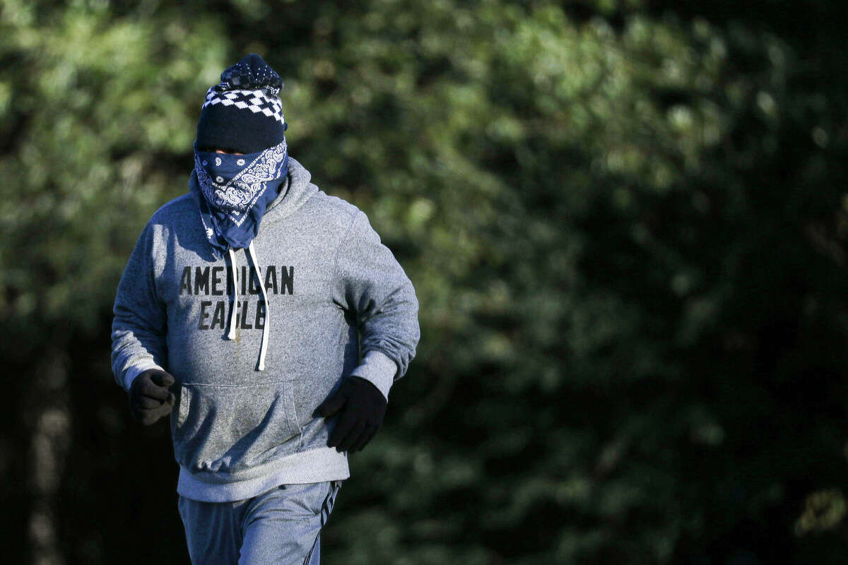 A antheral   jogs bundled up   on  the parking batch  astatine  Carl Barton Jr. Park successful  14-degree weather, Friday, Dec. 23, 2022, successful  Conroe.