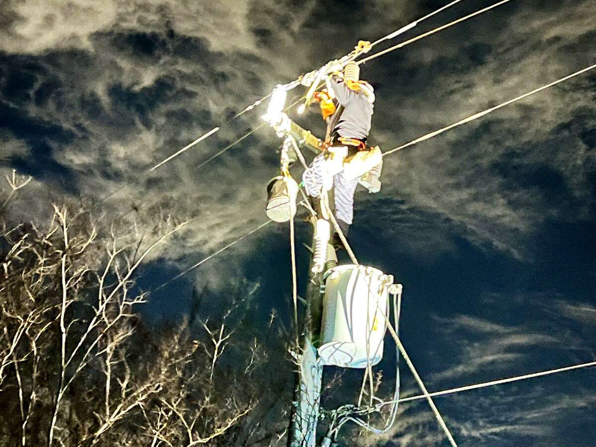 A CPS Energy worker repairs an outage near Marbach Road and Highway 90 on Thursday night.