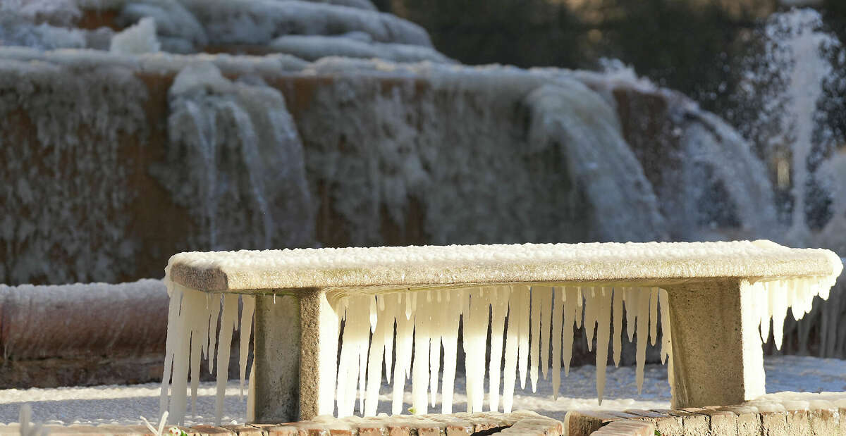 A bench downwind from the fountain at Bob Smith Park in downtown Houston is covered in ice as temperatures remain below freezing on Friday, Dec. 23, 2022.