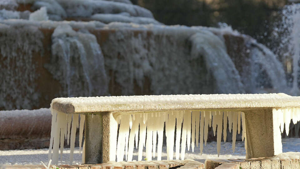 A bench downwind from the fountain at Bob Smith Park in downtown Houston is covered in ice as temperatures remain below freezing on Friday, Dec. 23, 2022.