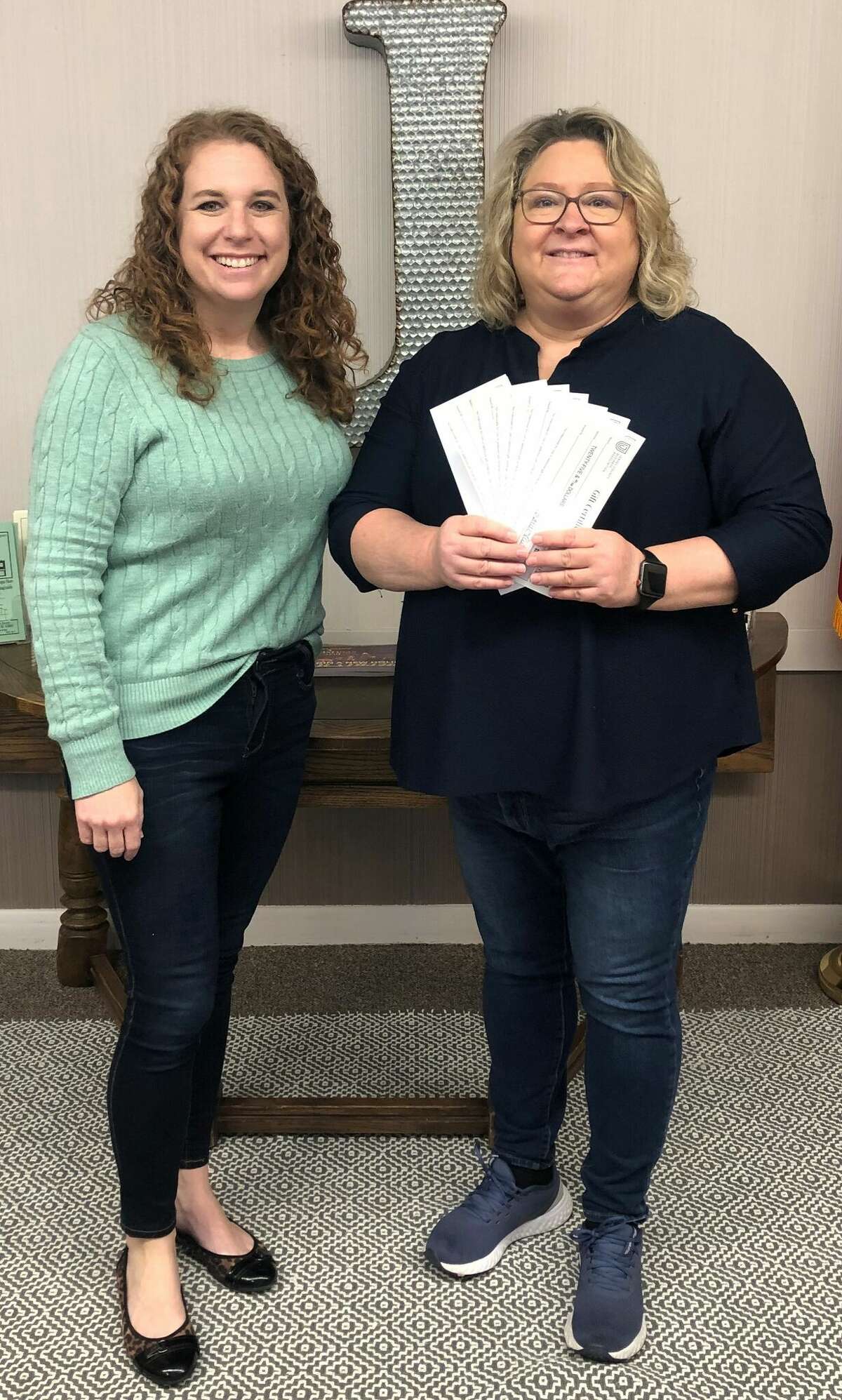 JCBA Director Rebecca Wayne, left, presents first place winner Carrie Flynn with her prize in the Jersey County Business Association's "12 Days of Christmas" Shopping Adventure.