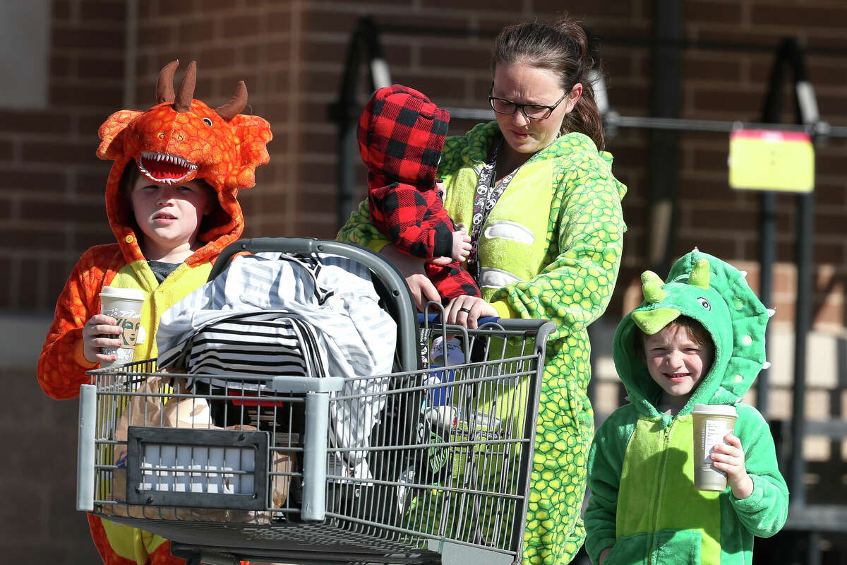 Konnor Knox, left, and his brother, Killian, deterioration  dinosaur pajamas alongside their mother, "They're conscionable  amusive  and astir   importantly, they're warm," Ashley Knox said of the family's attire successful  the 25-degree, windy weather.