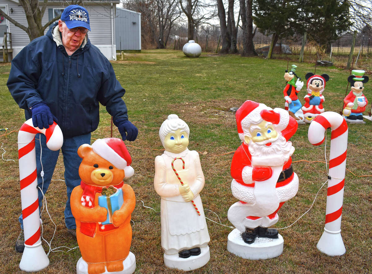 James Clayton arranges some of the vintage plastic Christmas characters that grace his yard on North Mount Zion Road in rural Jacksonville.