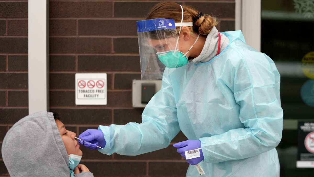 A nurse administers a COVID-19 test outside the Salt Lake County Health Department, Tuesday, Dec. 20, 2022, in Salt Lake City. (AP Photo/Rick Bowmer)